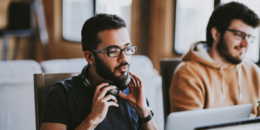 Image of two men sat in an office, working in the tech sector